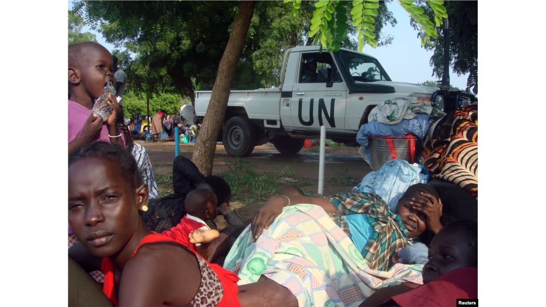FILE - A U.N. truck drives past displaced South Sudanese families resting in a camp for internally displaced people in the United Nations Mission in South Sudan (UNMISS) compound in Tomping, Juba, July 11, 2016.