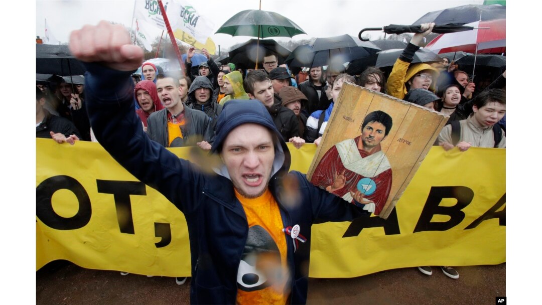 A man shouts whilst holding a portrait of messaging app Telegram co-founder Pavel Durov designed as an icon, to protest against the blocking of the app in Russia, during a May Day rally in St. Petersburg, Russia, May 1, 2018.