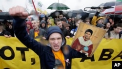 FILE - A man shouts while holding a portrait of messaging app Telegram co-founder Pavel Durov designed as an icon, to protest the blocking of the app in Russia, during a May Day rally in St. Petersburg, Russia, May 1, 2018.