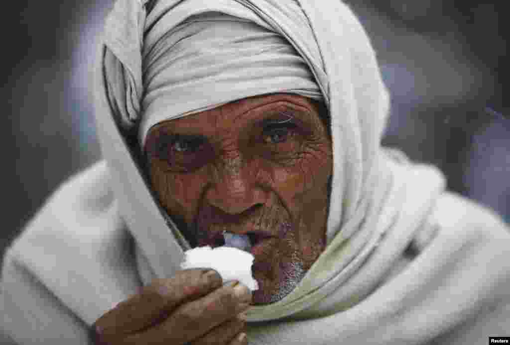 A passenger eats snow to quell thirst and hunger after a bus stalled on Bhimdatta Pant Highway during heavy snowfall in the far western region of Nepal, around 800 km (497 miles) from Kathmandu.