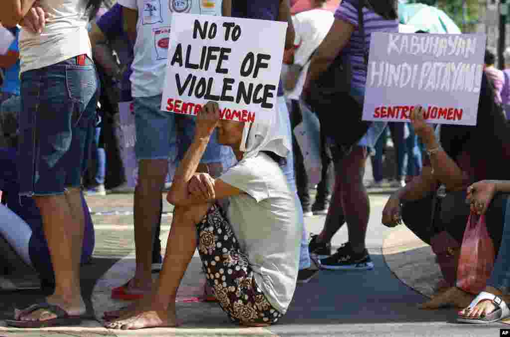 Protesters, mostly women, display placards during a rally ahead of the global action to mark the International Day for the Elimination of Violence Against Women, in suburban Quezon city northeast of Manila, Philippines.