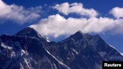 Cloud rise behind Mount Everest, the world's highest peak at 29,029 ft., viewed from Kongde, near Namche Bazar, Nepal, March 5, 2009.