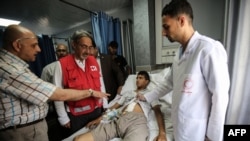 FILE - Francesco Rocca (2nd-L), the President of the International Federation of Red Cross and Red Crescent Societies, meets a Palestinian receiving treatment for wounds sustained during protests at the Gaza-Israel border, during his tour of the Red Crescent Hospital in Khan Yunis in the southern Gaza Strip, May 22, 2018.