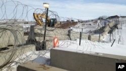 FILE - Razor wire and concrete barriers protect access to the Dakota Access pipeline drilling site, Feb. 9, 2017, near Cannon Ball, North Dakota.