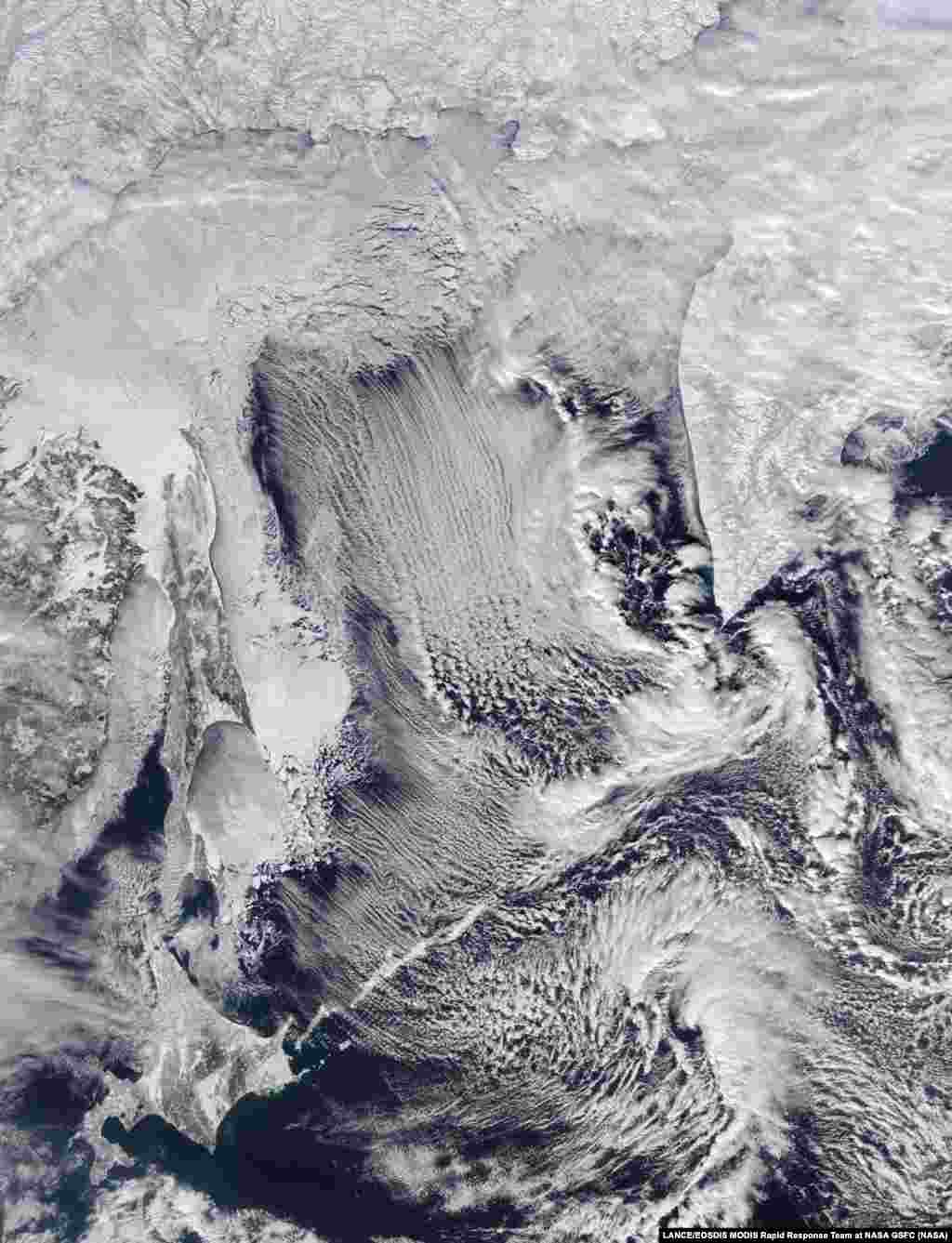 The Moderate Resolution Imaging Spectroradiometer (MODIS) instrument on NASA&#39;s Aqua satellite captured this image of cloud streets and sea ice in the Sea of Okhotsk on Feb. 8, 2016.