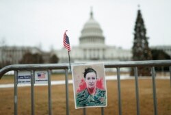 Un retrato de Ashli Babbitt, quien resultó muerta a tiros durante el ataque, puede verse en la cerca del Capitolio de EE. UU.