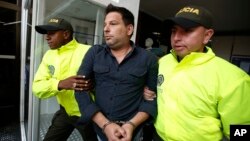 Polisi Kolombia membawa tersangka Raul Gutierrez dalam sidang di pengadilan Bogota, Kolombia, Kamis (15/4). 