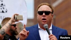 FILE - Alex Jones from Infowars.com speaks during a rally in support of Republican presidential candidate Donald Trump near the Republican National Convention in Cleveland, Ohio, July 18, 2016.