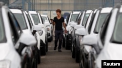 FILE - A worker checks cars made by GM Korea in a yard of GM Korea's Bupyeong plant before they are transported to a port for export, in Incheon, west of Seoul, Aug. 9, 2013. 