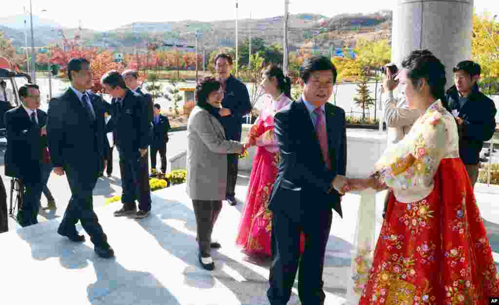 South Korean lawmakers are greeted by North Korean women upon their arrival at the inter-Korean industrial park in Kaesong, North Korea, Oct. 30, 2013.