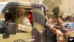 Tuareg fighters from the Movement for the Liberation of Azawad sit in their vehicle in a market in Timbuktu, Mali, April 14, 2012.