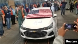 FILE - Employees watch as the last Chevrolet Cruze rolls off the assembly line at the General Motors Co assembly plant in Lordstown, Ohio, March 6, 2019, in this photo obtained from social media.
