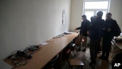 FILE - Belsat journalists examine empty tables after Belarusian police conducted a search and confiscated equipment in the broadcaster's office in capital Minsk, Belarus, March 31, 2017. A similar raid was conducted Tuesday.