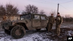 En esta foto del 20 de enero de 2022, soldados ucranianos están parados en su Hamvee en la línea de separación de los rebeldes prorrusos, Mariupol, región de Donetsk, Ucrania.