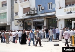 People queue to withdraw money at a bank in Tripoli, Libya, May 25, 2016.