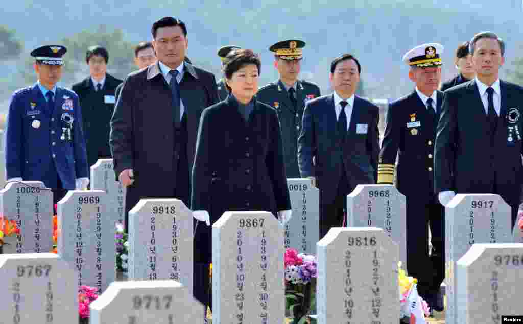 박근혜 한국 대통령(가운데)이 26일 국립대전현충원에서 열린 천안함 용사 3주기 추모식에 앞서 희생자들의 묘로 향하고 있다.