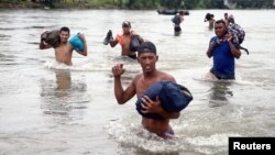 Central American migrants, part of a caravan trying to reach the U.S., cross the Suchiate River to avoid the border checkpoint in Ciudad Hidalgo, Mexico, Oct. 20, 2018.