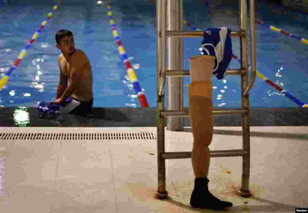 Motasim Abu Karsh, người Palestine bị cụt hai chân sau khi bị thương trong một trận không kích của Israel vào năm 2005, ngồi nghỉ sau khi bơi trong hồ bơi tại cuộc tranh tài địa phương ở Câu lạc bộ al-Sadaka Club thuộc thành phố Gaza.