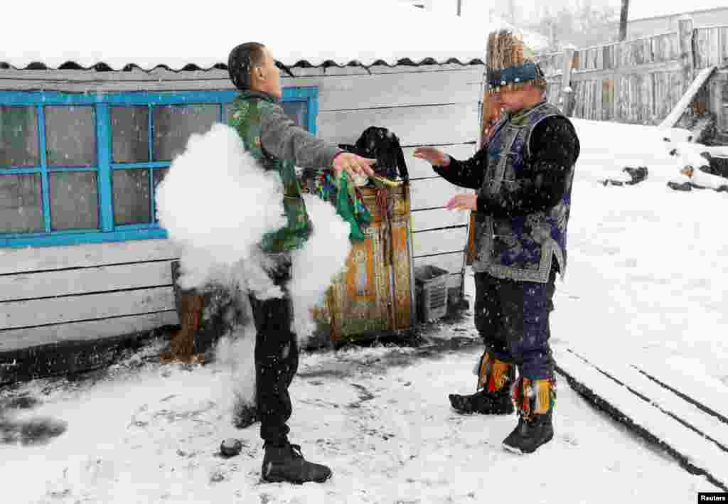 Duger Khomushku (R), a shaman representing the so-called Dungur society, conducts a spiritualistic session with a customer on the exorcism of evil spirits at a court yard of his residence in the town of Kyzyl, the administrative center of the Republic of of Tuva (Tyva region) in Southern Siberia, Russia.