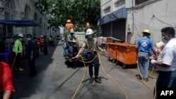 မြန်မာကြက်ခြေနီဝန်ထမ်းတွေ Covid-19 မပြန့်ပွားရေးအတွက် ရန်ကုန်မြို့အတွင်း ပိုးသတ်ဆေး လိုက်ဖြန်းနေစဉ်။ 