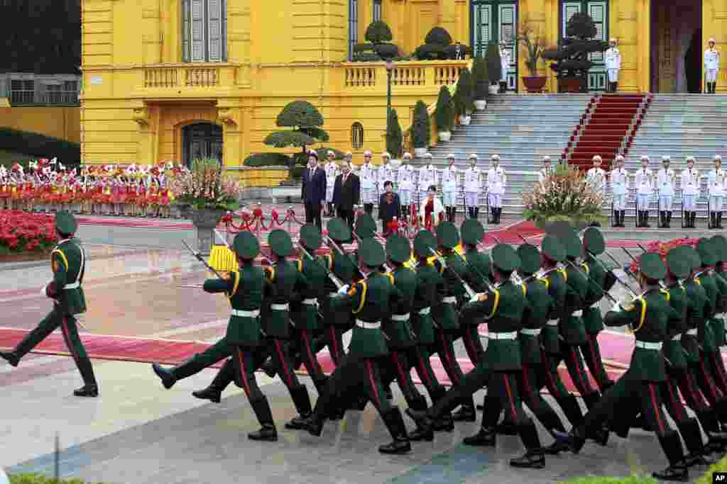 PM Jepang Shinzo Abe, kiri, dan rekannya dari Vietnam, Nguyen Xuan Phuc, kedua dari kiri, didampingi oleh istri-istri mereka, Akie Abe, kedua dari kanan, dan Tran Nguyet Thu, kanan memeriksa pasukan kehormatan di Istana Presiden di Hanoi, Vietnam.