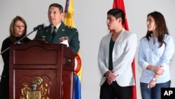 Army Gen. Ruben Alzate reads a statement at the military hospital in Bogota accompanied by his wife Claudia Farfan, left, his son Juan Pablo, second from right, and daughter Maria Paula, Dec. 1, 2014. 