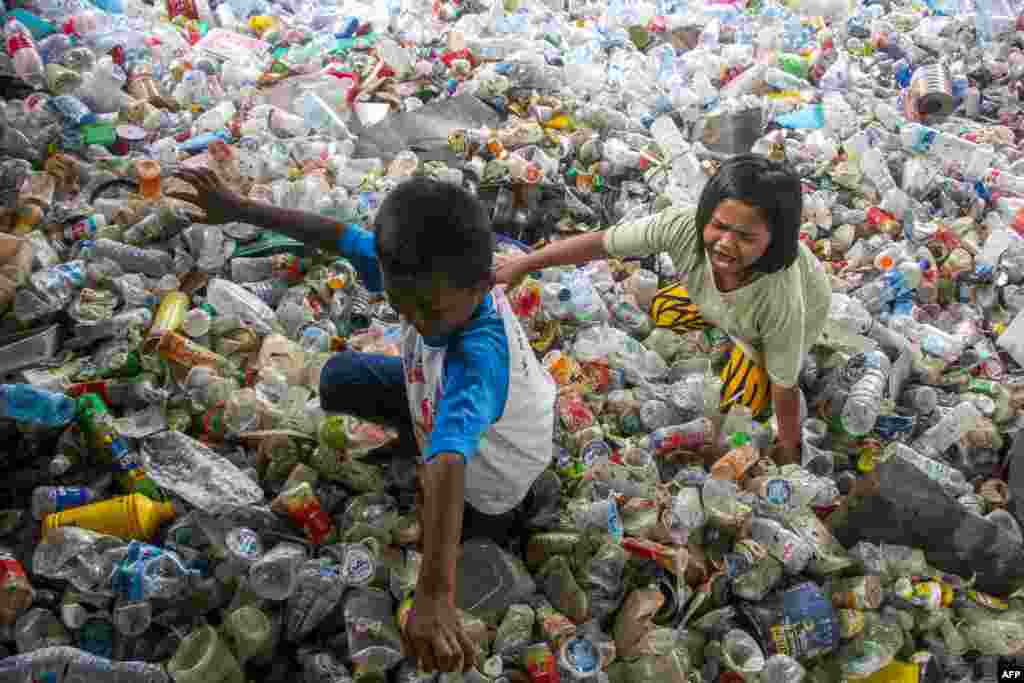Children play in a large amount of plastic waste collected for recycling in Makassar, Indonesia.