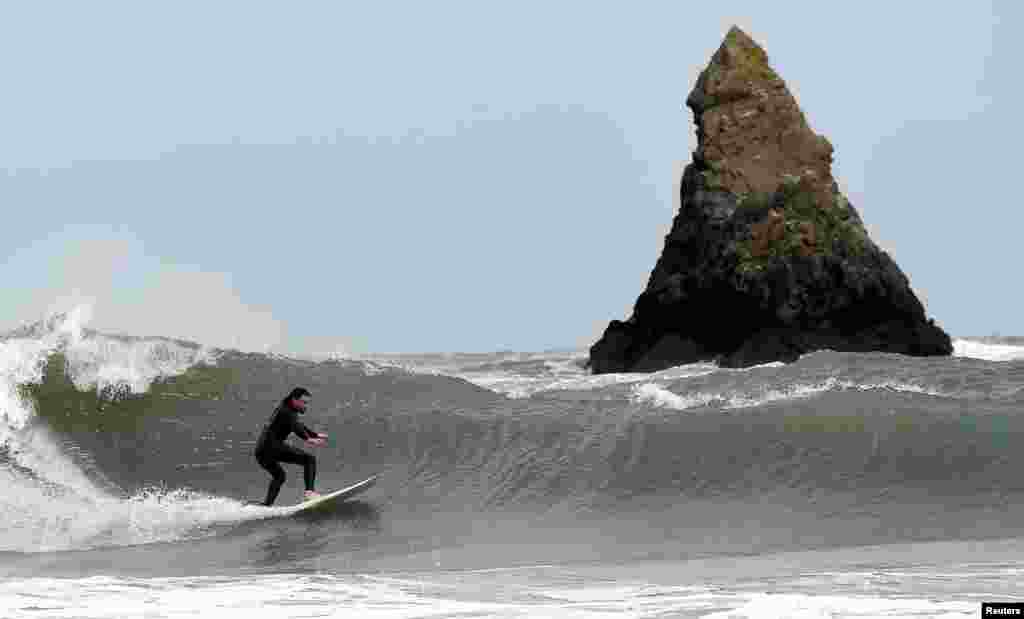 A surfer catches a wave near Church Rock, Broad Haven, Pembrokeshire, Wales, Britain, Sept. 19, 2018.