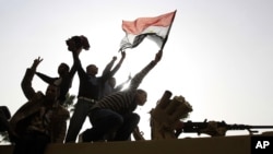 Men stand on top of an armored Egyptian Army vehicle during a protest in Cairo, Jan 29, 2011