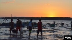 FILE - Fishermen return from a day of fishing nearby in the South China Sea, while others head out for overnight fishing, Masinloc, Philippines, Nov. 8, 2015. (S. Orendain/VOA)