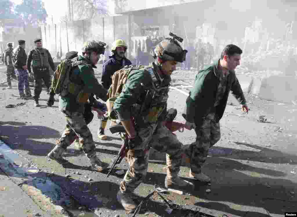 A wounded person is carried by soldiers at the site of a suicide bomb attack in Kirkuk, Iraq, February 3,2013. 