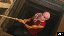 资料照片：一名巴勒斯坦人爬出连接加沙与埃及的隧道（2009年12月10日）（法新社）