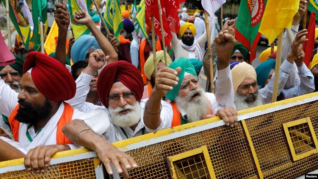 Petani meneriakkan slogan-slogan saat berlangsungnya aksi protes duduk menentang undang-undang pertanian, dekat gedung parlemen, di New Delhi, India, 22 Juli 2021. (REUTERS/Adnan Abidi)

