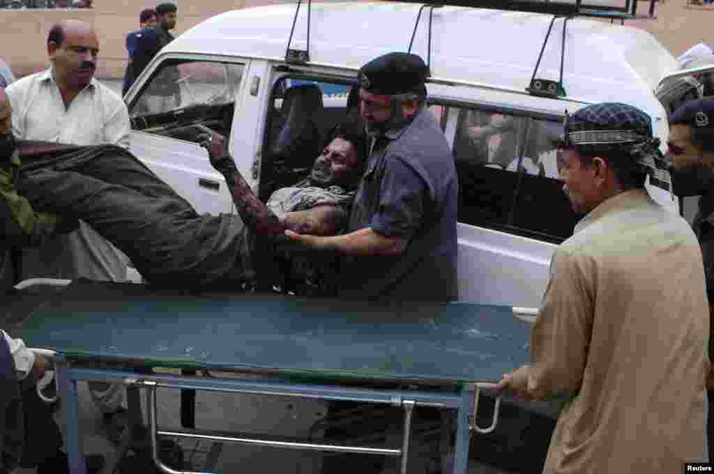کارکنان بیمارستان مردی را که در اثر انفجار بمب آسیب دیده از آمبولانس به بیمارستان منتقل می کنند. انفجارهای روز جمعه امید به ادامه صلح میان دولت با مخالفان را نقش بر آب کرد - پیشاور، ۱۴ مارس ۲۰۱۴