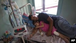 Archivo - Maykol Pacheco junto a su hija Ashley en la cama del Hospital Universitario en Caracas, Venezuela, el 11 de agosto de 2016.