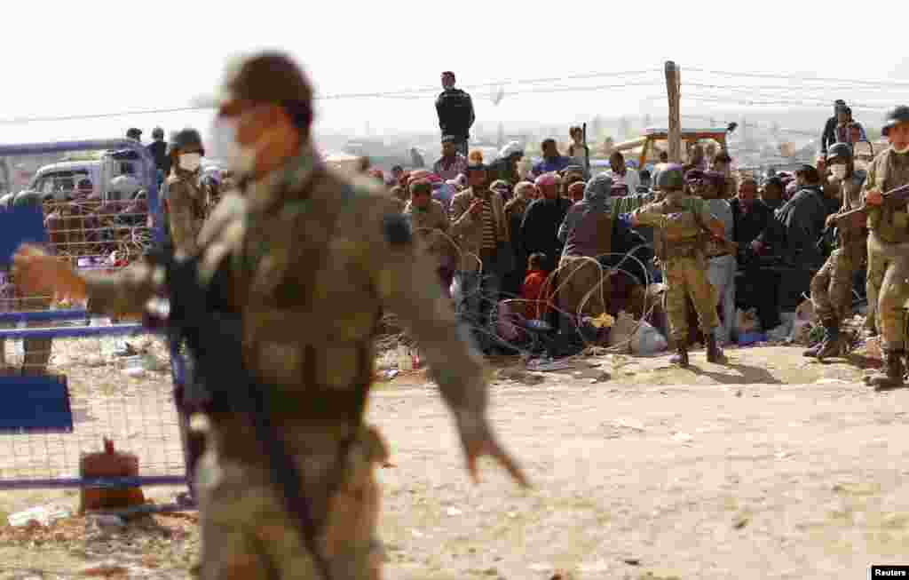 Syrian Kurdish refugees wait to cross into Turkey from the Syrian border town Kobani, near the southeastern Turkish town of Suruc in Sanliurfa province, Oct. 2, 2014.