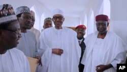 In this photo released by the Nigeria State House, Nigeria's President Muhammadu Buhari, center, with government officials after Friday prayers at the presidential palace in Abuja, Nigeria, May. 5, 2017. 