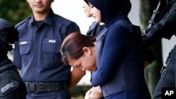 Salah satu tersangka dalam kasus pembuhunan Kim Jong-nam, Siti Aisyah (tengah) dikawal ketat oleh petugas kepolisian saat meninggalkan pengadilan di Sepang, Malaysia, 13 April 2017. (AP Photo/Vincent Thian)