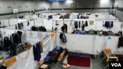 A gym is separated into cubicles where refugees sleep on cots, in a camp near Holzdorf, Germany, Nov. 29, 2015. Residents say the lack of outside interaction makes them feel isolated, and more like prisoners than asylum-seekers. (VOA News)