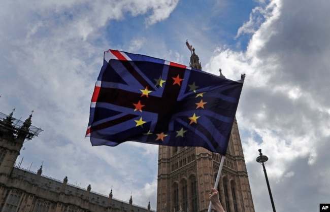 A pro EU protestor waves flags opposite the House of Parliament in London, April 4, 2019.