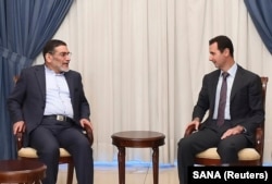 FILE - Syria's President Bashar al-Assad, right, meets Admiral Ali Shamkhani, Iran's Supreme National Security Council Director, in Damascus, Sept. 30, 2014.