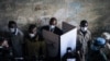 Le président de la République centrafricaine Faustin Archange Touadera dans un isoloir entouré par la garde présidentielle au bureau de vote du lycée Barthélemy Boganda dans le 1er district de Bangui, en RCA, le 27 décembre 2020