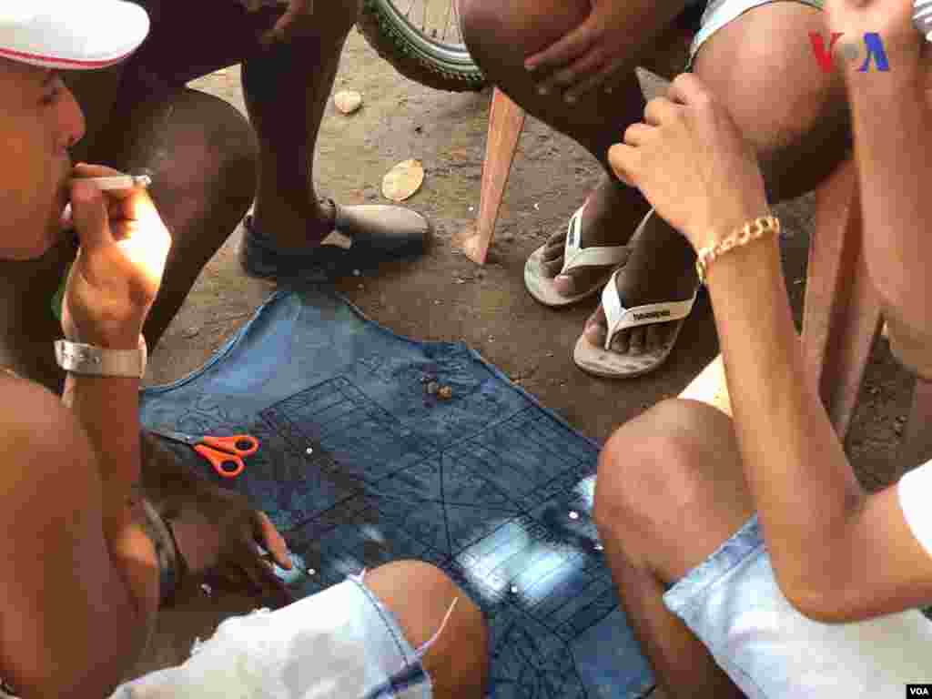 Personas juegan con un tablero hechos por ellos en refugio improvisado&nbsp;creado por venezolanos en el vecindario Jardim Floresta, fronterizo de Brasil. Foto: Celia Mendoza - VOA