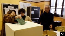 A voter casts her ballot in Rome, Sunday, March 4, 2018.