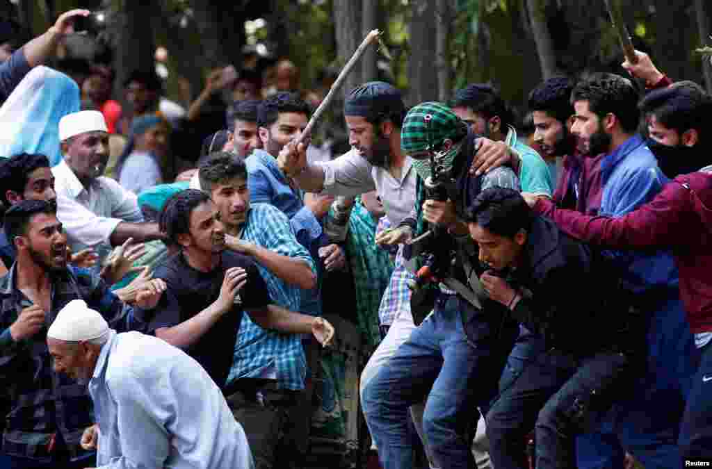 People run during a funeral of Suhail Ahmad Dar, a suspected militant, who according to local media was killed in a gun battle with security forces, in south Kashmir&#39;s Kulgam district, India.