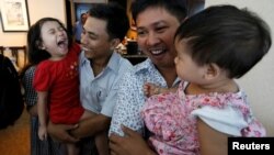 Reuters reporters Wa Lone and Kyaw Soe Oo celebrate with their children after being freed from prison, after receiving a presidential pardon in Yangon, Myanmar, May 7, 2019.