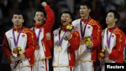 Feng Zhe (L-R) of China and teammates Guo Weiyang, Chen Yibing, Zhang Chenglong and Zou Kai celebrate with their gold medals after taking first place in the men's gymnastics team final in the North Greenwich Arena at the London 2012 Olympic Games, July 30