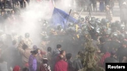 In this handout photo released by The International Campaign for Tibet (ICT) on December 7, 2012, paramilitary policemen are seen closing in on Dorje Rinchen's body after his self-immolation, in Xiahe, Gannan Tibetan Autonomous Prefecture, Gansu province,