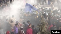 In this handout photo released by The International Campaign for Tibet (ICT) on December 7, 2012, paramilitary policemen are seen closing in on Dorje Rinchen's body after his self-immolation, in Xiahe, Gansu province, October 23, 2012. 