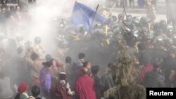 In this handout photo released by The International Campaign for Tibet (ICT) on December 7, 2012, paramilitary policemen are seen closing in on Dorje Rinchen's body after his self-immolation, in Xiahe, Gannan Tibetan Autonomous Prefecture, Gansu province, October 23, 2012.